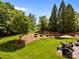 Green backyard featuring a table with an umbrella, landscaping, and stairs to the upper yard at 1900 Birchbrook Ct, Harrisburg, NC 28075