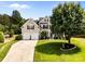Beautifully landscaped two-story home with a spacious lawn, mature tree, and convenient two-car garage at 1900 Birchbrook Ct, Harrisburg, NC 28075