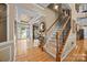 Elegant foyer featuring hardwood floors, a staircase with iron railings, and a view of the front door at 1900 Birchbrook Ct, Harrisburg, NC 28075
