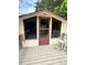 Building exterior with multiple windows, a red door, and wooden rocking chairs on a porch at 2030 Keisler Dairy Rd, Conover, NC 28613