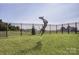 Fully fenced backyard showing grassy area where dog is catching a frisbee at 2049 Stephens Farm Dr, China Grove, NC 28023