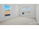 Bedroom with neutral carpet, white trim, and two bright windows at 2176 Millennium Dr # 093, Lancaster, SC 29720