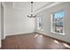 Airy dining room with hardwood floors, tray ceiling, modern chandelier, and natural light from adjacent windows at 2176 Millennium Dr # 093, Lancaster, SC 29720