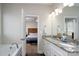 Well-lit bathroom with double vanity, granite countertops, and a soaking tub with an open doorway to bedroom at 2205 Philadelphia Church Rd, Dallas, NC 28034