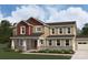 Charming two-story home featuring stone accents, beige siding, and a welcoming front porch at 2526 Mabel Ln, Monroe, NC 28110