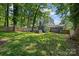 Landscaped backyard with well-maintained lawn, wood fence, gray brick house, patio with outdoor furniture and hot tub at 2933 Hilliard Dr, Charlotte, NC 28205