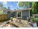 This wooden backyard patio features string lights, a gray brick house, and an outdoor dining set on a sunny day at 2933 Hilliard Dr, Charlotte, NC 28205