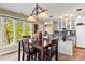 Cozy dining area featuring a wooden table set, complemented by ample natural light and a partial view of the adjacent kitchen at 372 Northwest Dr, Davidson, NC 28036