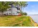 Multi-story lake house with balconies overlooking the serene water, surrounded by lush greenery at 372 Northwest Dr, Davidson, NC 28036
