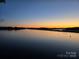 Stunning sunset over the calm lake, casting a warm glow on the water, creating a peaceful ambiance at 372 Northwest Dr, Davidson, NC 28036
