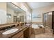 Spa-like bathroom featuring double sinks, a soaking tub, and a glass-enclosed shower at 4122 Banfield Pl, Charlotte, NC 28226