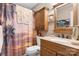 Bathroom with single sink vanity, granite countertop, and tropical shower curtain at 4705 Campground View Rd, Catawba, NC 28609