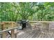 Outdoor deck with a grill and a table with chairs surrounded by mature trees at 4705 Campground View Rd, Catawba, NC 28609