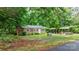 Quaint home with metal roof, brick exterior, green lawn, framed by mature trees offering a private setting at 4705 Campground View Rd, Catawba, NC 28609