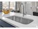 Close-up of a modern kitchen sink with quartz countertop and view into the dining area at 5201 Shasta St # 5201, Gastonia, NC 28052