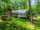 The rear exterior of the home surrounded by a lush green backyard with mature trees and well-maintained landscaping at 532 Courtney Ln, Matthews, NC 28105