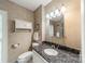 Bathroom with granite countertop, sink, and wall storage at 532 Courtney Ln, Matthews, NC 28105