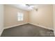 Empty bedroom with neutral carpet and walls, featuring a window with plantation shutters at 532 Courtney Ln, Matthews, NC 28105