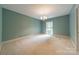 Empty bedroom with neutral carpet and walls, featuring a window with natural light at 532 Courtney Ln, Matthews, NC 28105