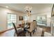 Dining room features a shiny table with six chairs, large bright windows and chandelier at 532 Courtney Ln, Matthews, NC 28105