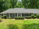 Straight-on view of the house with a green lawn and mature shrubbery framing the property at 532 Courtney Ln, Matthews, NC 28105