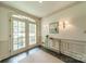 View of the foyer showcasing a decorative rug, tiled floor, an ornate table and a set of sconces at 532 Courtney Ln, Matthews, NC 28105