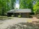 Three-car detached garage with a gravel driveway, perfect for car enthusiasts or extra storage, and mature trees at 532 Courtney Ln, Matthews, NC 28105