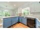 Updated kitchen features stainless steel appliances, granite counters, and stylish blue and white cabinetry at 532 Courtney Ln, Matthews, NC 28105