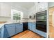 Updated kitchen features stainless steel appliances, granite counters, and stylish blue and white cabinetry at 532 Courtney Ln, Matthews, NC 28105