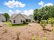 View of home and backyard featuring sunroom, grass, and pine straw at 581 Harrison Nw Dr, Concord, NC 28027