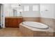 Serene bathroom featuring a soaking tub with tile surround and custom cabinetry at 581 Harrison Nw Dr, Concord, NC 28027