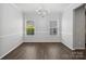 Formal dining room with wood-look floors, chandelier lighting, and two bright windows at 581 Harrison Nw Dr, Concord, NC 28027