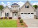 Charming home featuring stone accents, a two-car garage, manicured lawn and a covered front porch at 581 Harrison Nw Dr, Concord, NC 28027