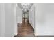 Hallway with dark hardwood flooring and bright white walls offers a view to windows at the end at 581 Harrison Nw Dr, Concord, NC 28027