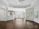Bright living room boasts wood floors, tray ceiling, and opens to the kitchen and patio at 581 Harrison Nw Dr, Concord, NC 28027