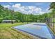 Backyard basketball court featuring a blue and gray surface, professional net and lighting, all surrounded by lush greenery at 6108 Phyliss Ln, Mint Hill, NC 28227