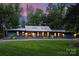 Beautiful ranch-style home with a metal roof, manicured lawn and professional landscaping at 6108 Phyliss Ln, Mint Hill, NC 28227