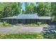 Ranch-style home with a modern metal roof, manicured lawn and professional landscaping at 6108 Phyliss Ln, Mint Hill, NC 28227