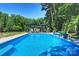 Inviting pool with lounge chairs, umbrellas and landscaping creating a relaxing outdoor living space at 6108 Phyliss Ln, Mint Hill, NC 28227