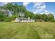 Charming single-story home featuring freshly cut grass and a painted brick facade and a bright teal front door at 6301 Vernedale Rd, Charlotte, NC 28212