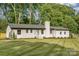 Inviting home with a lush green lawn, accented by dark mulch beds, and a prominent chimney feature at 6301 Vernedale Rd, Charlotte, NC 28212