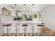 Modern kitchen with stainless steel appliances, white cabinets, a tile backsplash, and a breakfast bar at 6301 Vernedale Rd, Charlotte, NC 28212