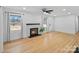 Bright living room features a fireplace, ceiling fan, and hardwood flooring at 6301 Vernedale Rd, Charlotte, NC 28212
