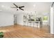 Open-concept living area with hardwood floors, ceiling fan, kitchen island with seating, and recessed lighting at 6301 Vernedale Rd, Charlotte, NC 28212