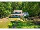 Aerial view of a well-maintained home surrounded by mature trees and colorful landscaping at 6766 Little Mountain Rd, Sherrills Ford, NC 28673