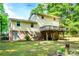 Spacious backyard featuring a covered deck, lush lawn, and mature trees, offering an ideal outdoor living space at 6766 Little Mountain Rd, Sherrills Ford, NC 28673