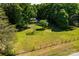 Expansive backyard with a large grassy area, surrounded by lush trees and a rustic fence, offering privacy and tranquility at 6766 Little Mountain Rd, Sherrills Ford, NC 28673
