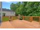 Back deck featuring a green lawn, potted plants, and a wooded treeline in the background at 7049 Sedgebrook W Dr, Stanley, NC 28164
