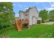 Backyard view featuring a well-kept lawn, wooden deck with stairs, and the home's exterior at 7049 Sedgebrook W Dr, Stanley, NC 28164