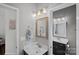 Well-lit bathroom featuring a single vanity with framed mirror and decorative lighting at 7049 Sedgebrook W Dr, Stanley, NC 28164